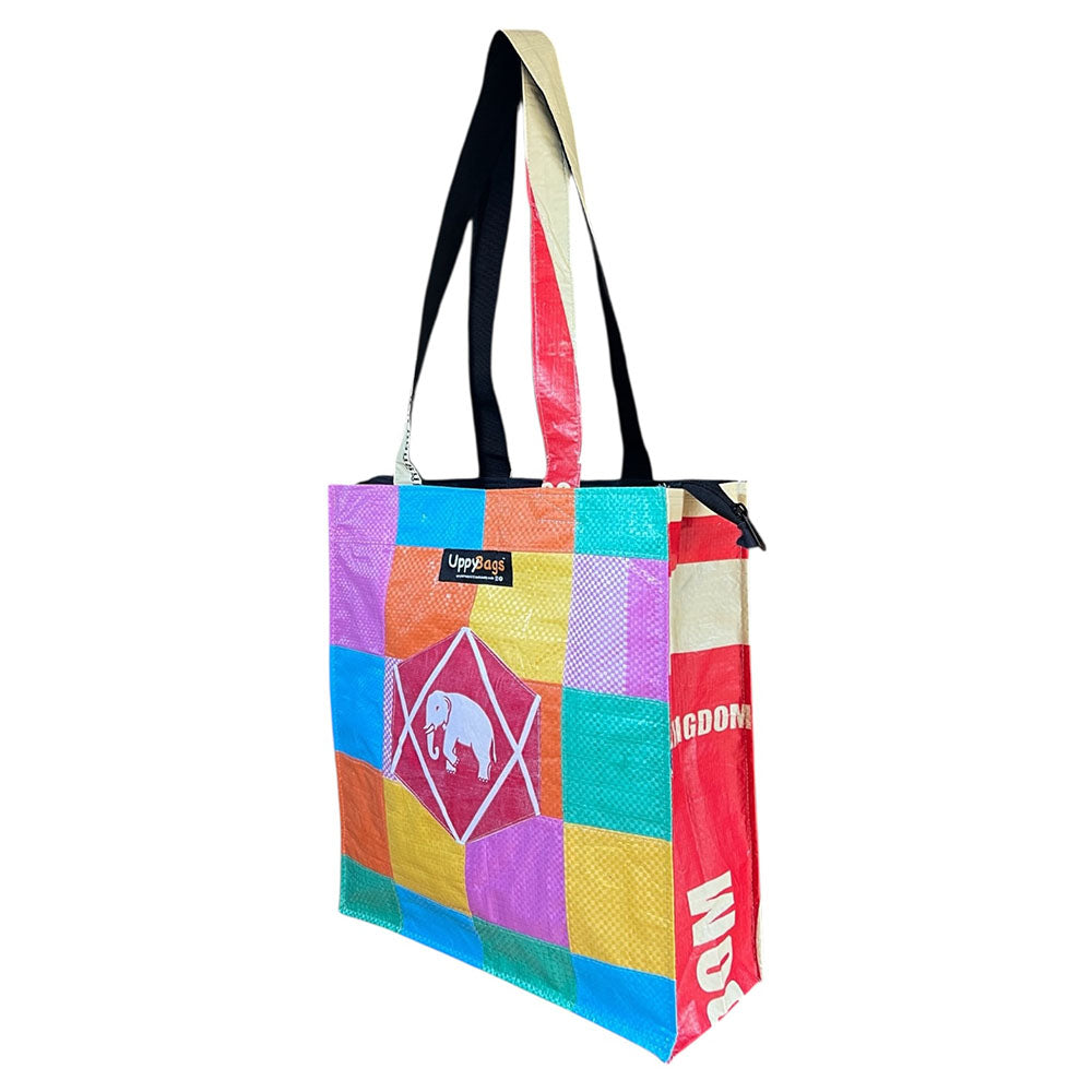 Colorful patchwork tote bag with geometric patterns and brand logos on a white background