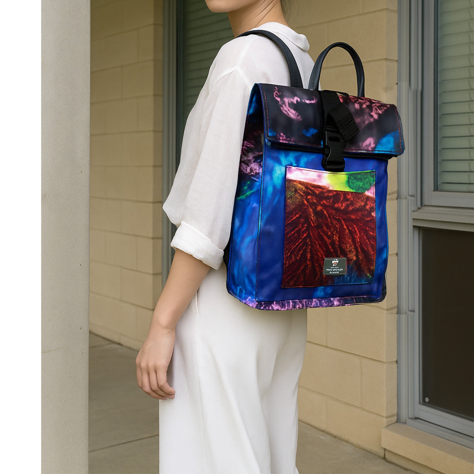 Person wearing a colorful backpack with a abstract design in an urban setting